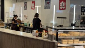 Two international students work behind the counter at a Chinese restaurant in Perth. (Photo: Genyvra Caecillia).